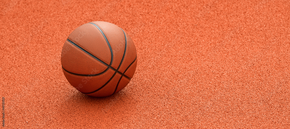 Orange basketball on brown court of gymnasium sport floor. Street basketball concept