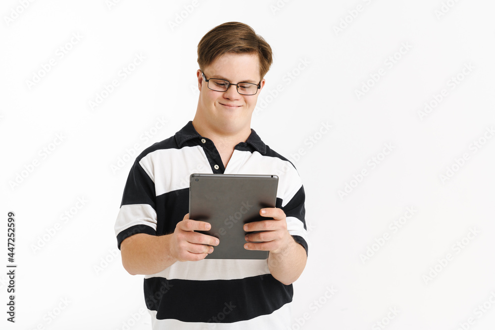 Young man with down syndrome smiling while using tablet computer Young man with down syndrome smiling while using tablet computer