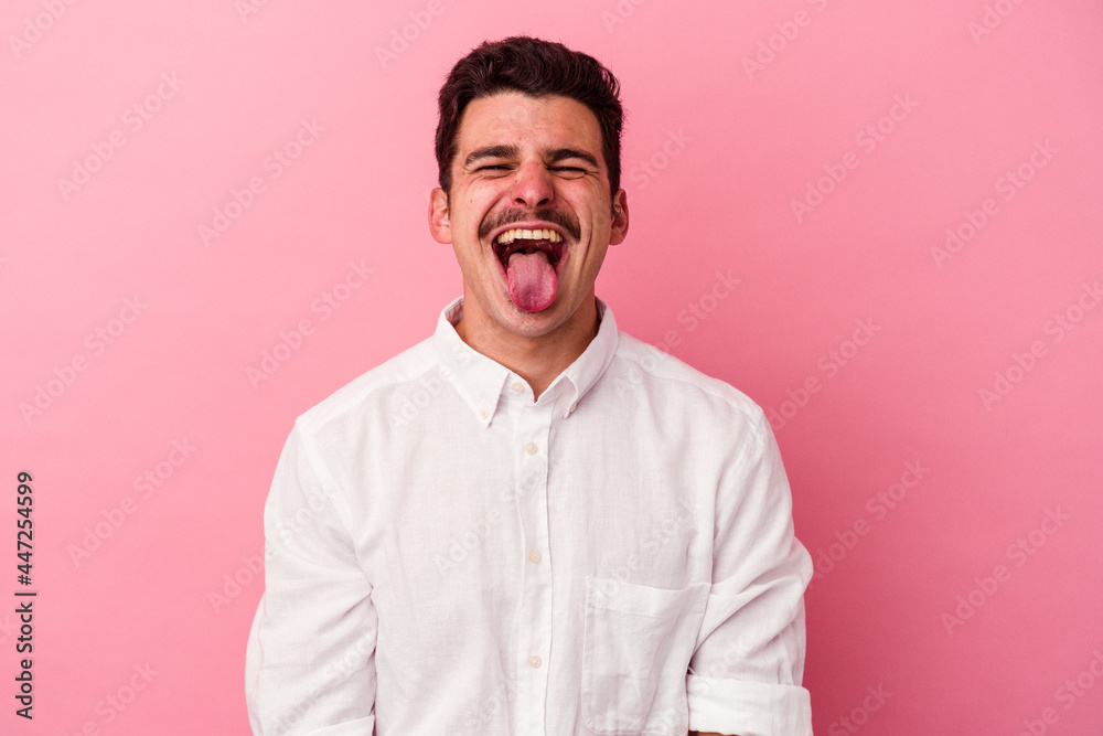 Young caucasian man isolated on pink background funny and friendly sticking out tongue. Young caucasian man isolated on pink background funny and friendly sticking out tongue.