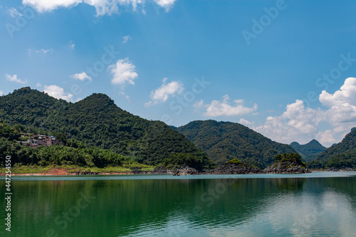 beautiful lake with and green meadows and forests and small islands on the lake. Beautiful natural landscape with lake and mountains.