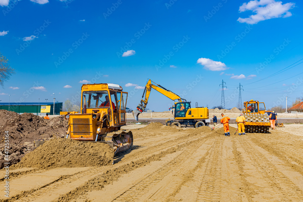 Obraz premium Bulldozer machine is leveling construction site.
