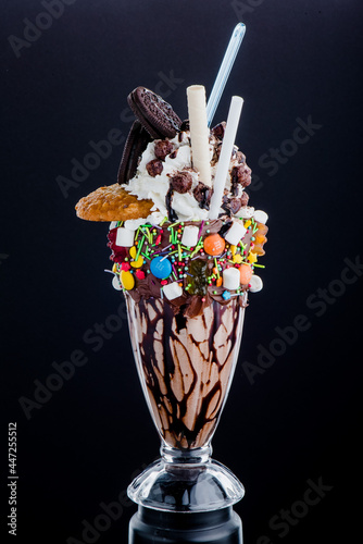 Chocolate freak shakes in a beautiful glass isolated on black background. Close-up. Space for text. High quality photo photo