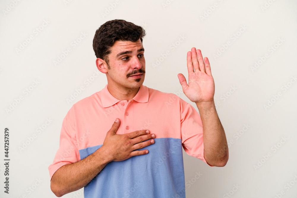Young caucasian man isolated on white background taking an oath, putting hand on chest. Young caucasian man isolated on white background taking an oath, putting hand on chest.