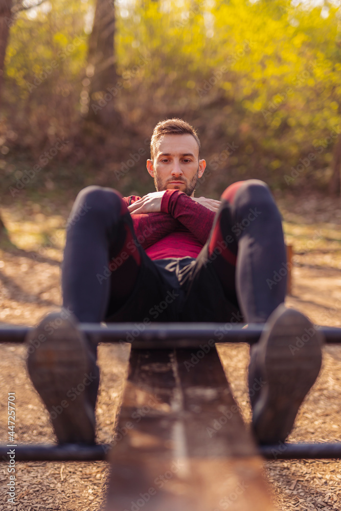 Fototapeta premium Man doing sit ups in street workout park