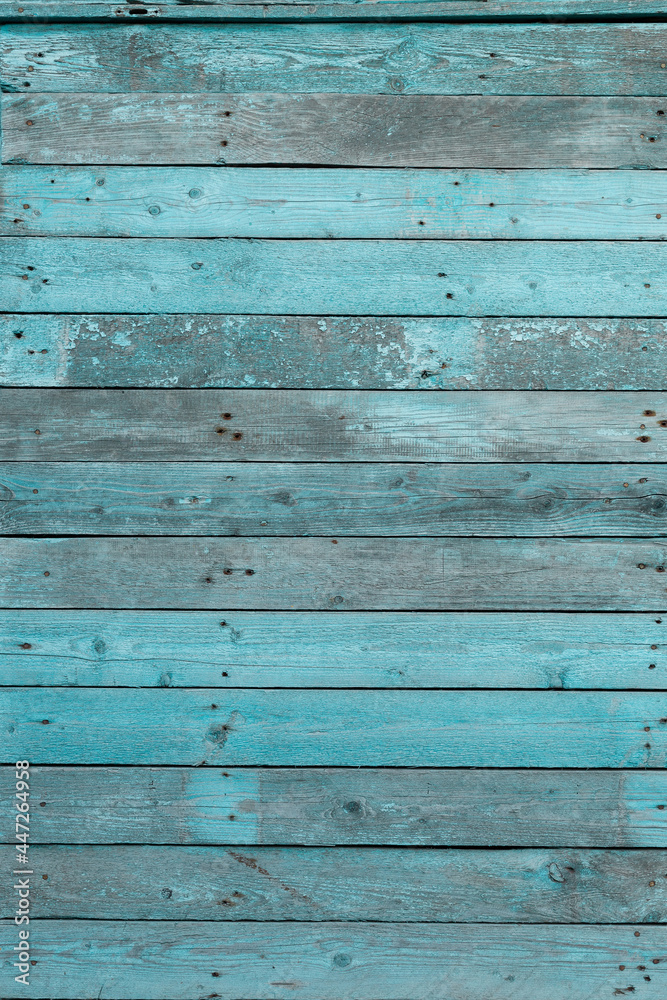 Obraz premium A piece of a wooden wall and a cracked blue paint