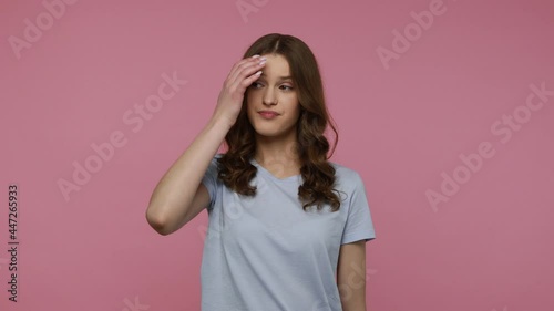 Pensive young woman with dark wavy hair in casual T-shirt solving serious problem in mind, thinking over smart idea, pondering and musing answer.Indoor studio shot isolated over pink background.