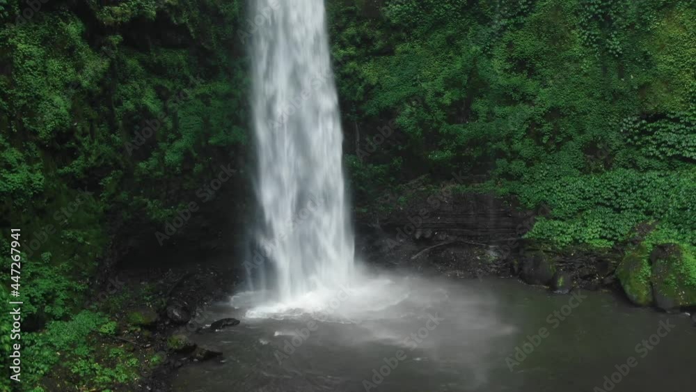 Waterfall in green rainforest. Aerial view of NungNung waterfall in the mountain jungle. Aerial footage. Bali, Indonesia. Travel concept. Waterfall in green rainforest. Aerial view of NungNung waterfall in the mountain jungle. Aerial footage. Bali, Indonesia. Travel concept.