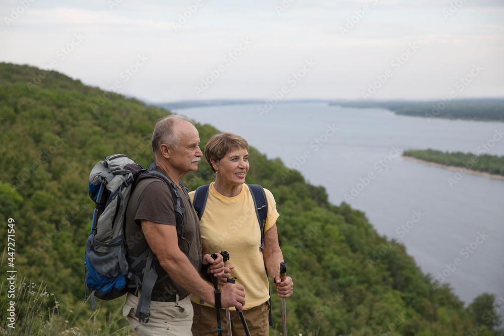 Senior couple with backpack hiking in outdoor.  Digital detox. Staycations, hyper-local travel,  family outing, getaway, natural environment