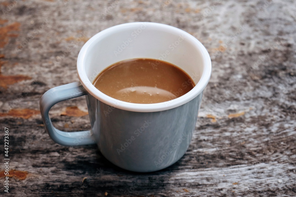 Hot coffee in blue cup on brown wood table background Hot coffee in blue cup on brown wood table background