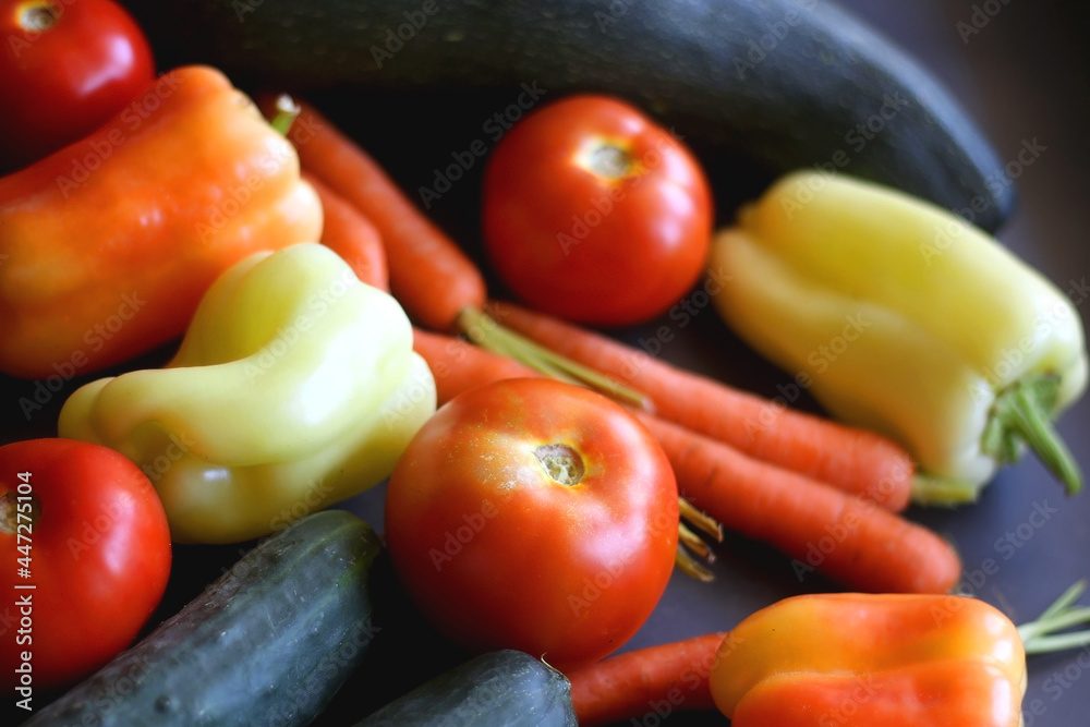 Zucchini, tomatoes, peppers, carrots and cucumbers on dark background. Selective focus. Zucchini, tomatoes, peppers, carrots and cucumbers on dark background. Selective focus.