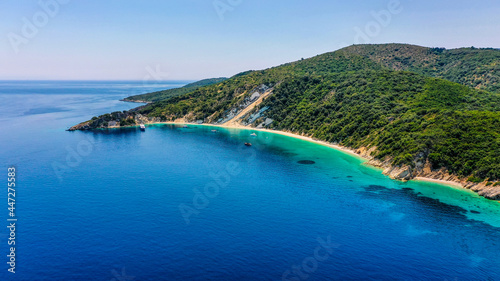 Drone shot of the blue and turquoise sea of Gidaki beach in Ithaca with luxury boats moored at the front