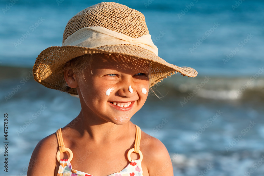 Children Sunscreen on Child Face. Sea Vacation Child Smiling Having Fun with Sunscreen on Face on Sea Background. Children Sea Vacation.
