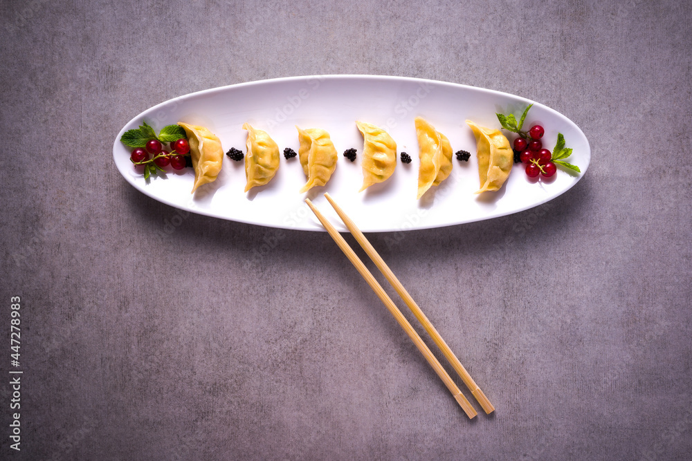 plate of japanese ravioli with chopsticks on stone background plate of japanese ravioli with chopsticks on stone background
