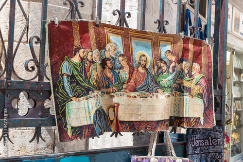 A carpet with a picture of the Last Supper on it hangs in a souvenir shop on Muristan street in the Christian quarter in the old city of Jerusalem, Israel photo