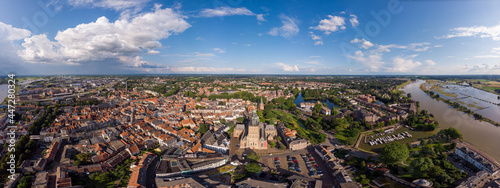 Wide cityscape aerial panorama of the Dutch medieval Hanseatic city of Zutphen in The Netherlands with the Walburgiskerk cathedral tower lit up in sunlight in urban landscape. © Maarten Zeehandelaar