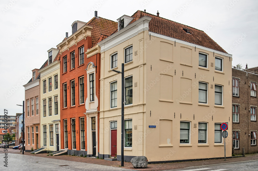 Vlissingen, The Netherlands, July 24, 2021: row of historic buildings on Bellamypark with facades painted in hues of red, brown and yellow