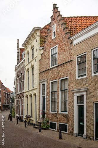 Fototapeta Naklejka Na Ścianę i Meble -  Vlissingen, The Netherlands, July 24, 2021: curving street in the old town lined with traditional facades in brick and plaster