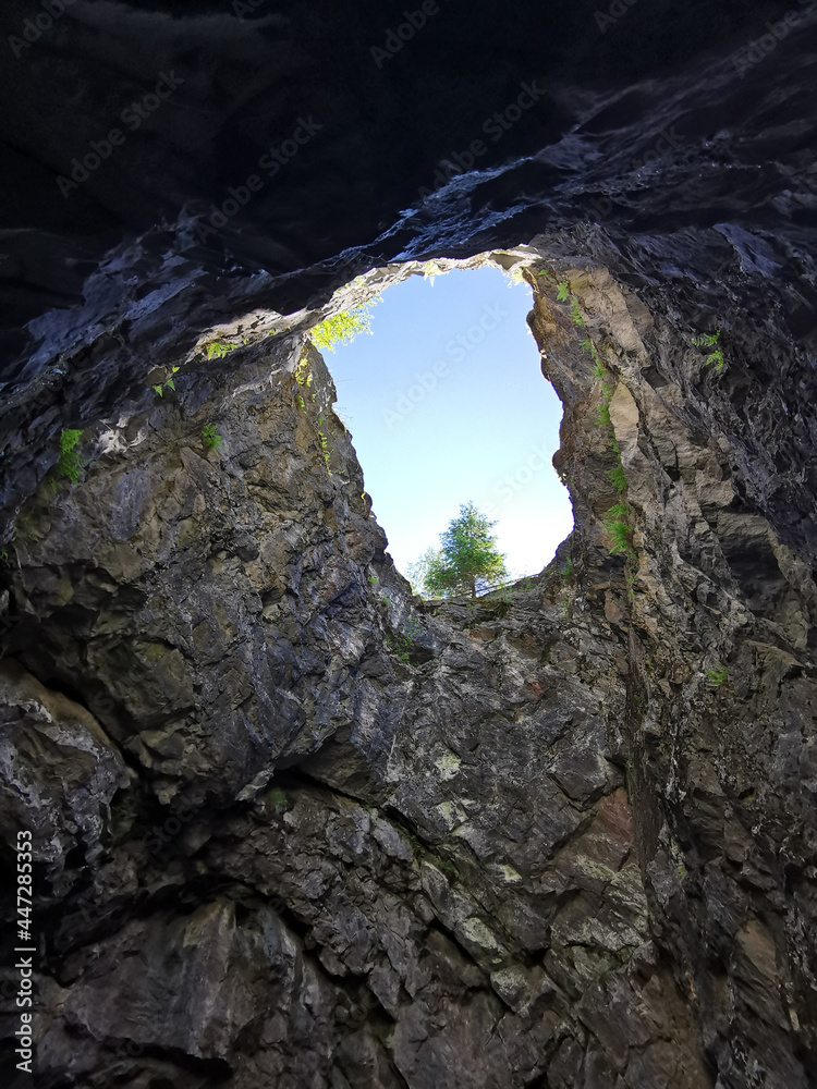 A view from below of the shaft of a vertical shaft, formerly used for marble mining, in the Ruskeala Mountain Park on a summer day.