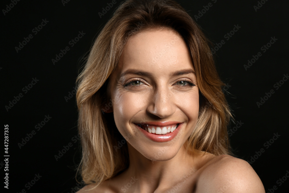 Portrait of happy young woman with beautiful blonde hair and charming smile on black background, closeup Portrait of happy young woman with beautiful blonde hair and charming smile on black background, closeup