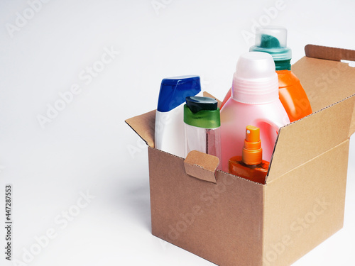 Photo of cleaning products standing on stacked cardboard boxes background.