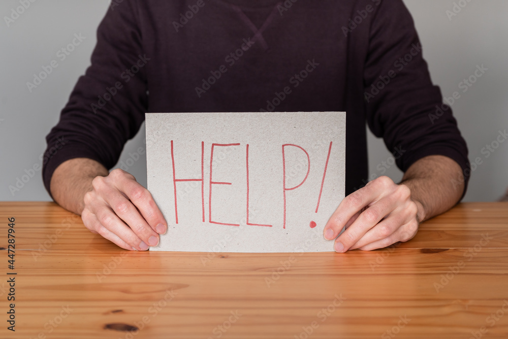 Unrecognizable person holding a sign asking for help. Unrecognizable person holding a sign asking for help.