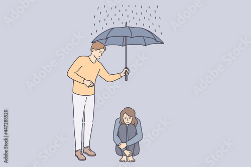 Helping hand and support concept. Young man cartoon character holding umbrella above sad frustrated depressed girl sitting on floor on rainy day vector illustration 