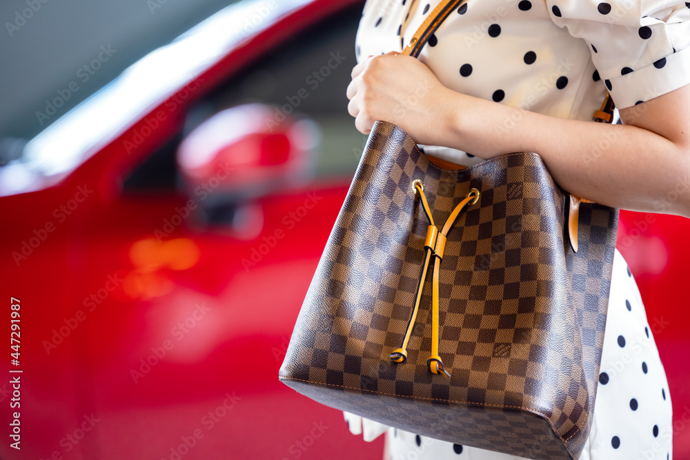 July 26, 2021: Nakhon Prathom, THAILAND, A woman carrying a Louis Vuitton  square bag. Louis Vuitton is a high-end fashion house known for its leather  goods. Stock-Foto | Adobe Stock