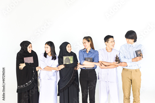 Photography Group of diverse religions people include Islam, Christ, Buddhist holding hands and looking each other on white background