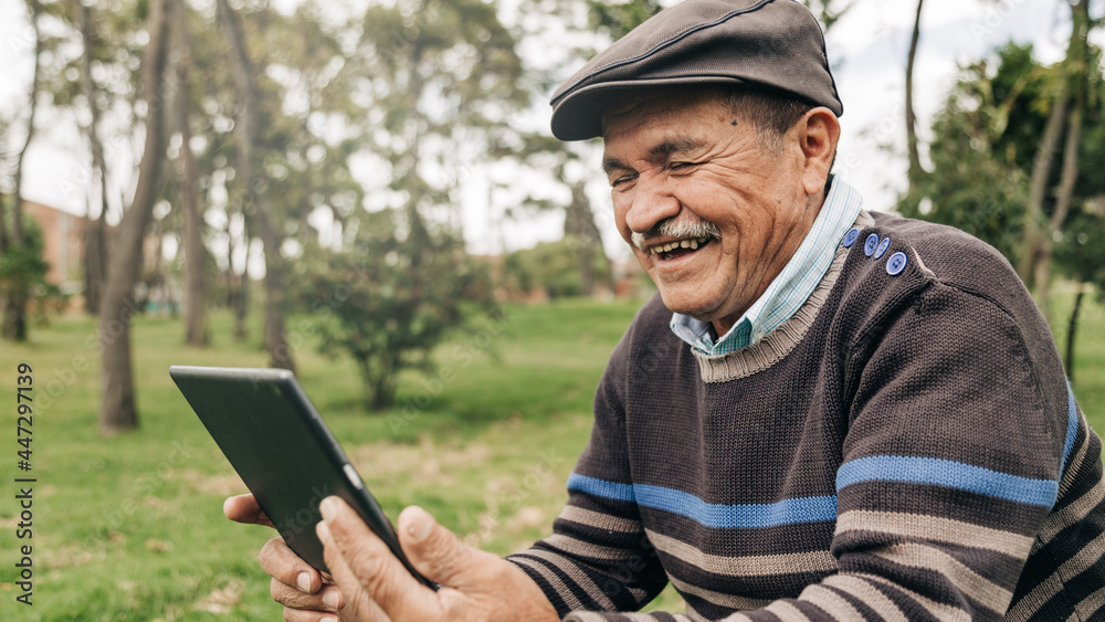 man greeting his relatives on the Tablet by video call, in the park