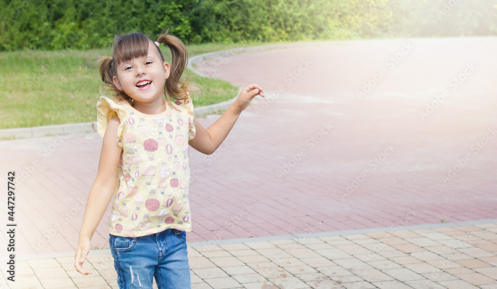 Naklejka premium Little happy jumping girl. Happy child on the street. Outdoor games
