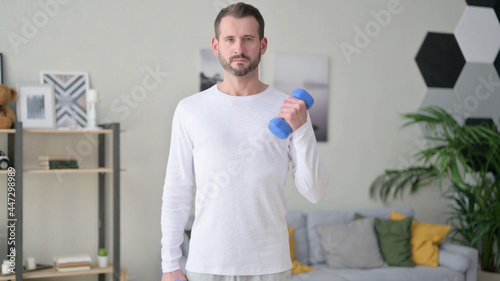 Close up of Young Man Working out with Dumbbells at Home
