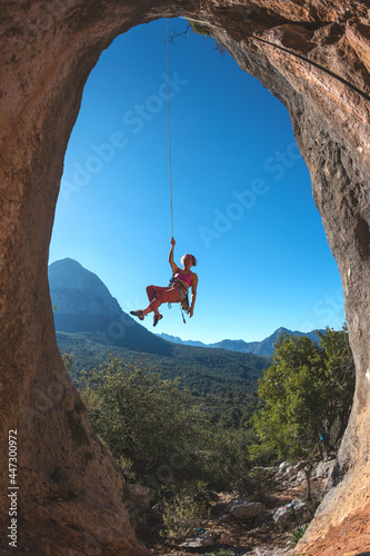 Rock climber descends from the route, the climber hangs on a rope