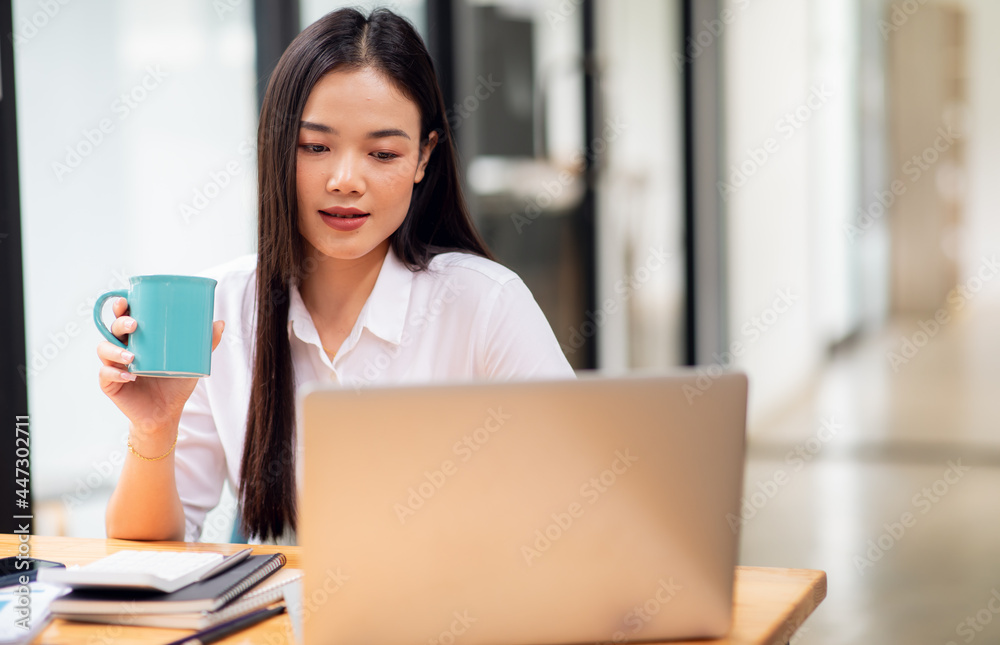 Young Business woman working on laptop computer for do math finance on wooden desk, tax, accounting, statistics report and analytical research concept Young Business woman working on laptop computer for do math finance on wooden desk, tax, accounting, statistics report and analytical research concept