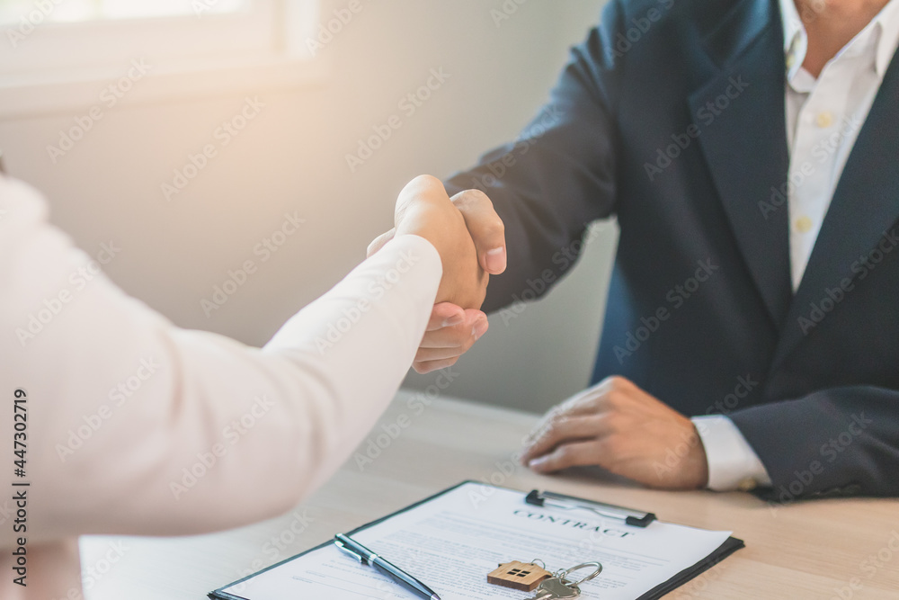 Close up hand of home, apartment agent or realtor handshake with newlandlord, tenant or rental. After the banker has approved and signed the purchase contract agreement successfully. Property concept. Close up hand of home, apartment agent or realtor handshake with newlandlord, tenant or rental. After the banker has approved and signed the purchase contract agreement successfully. Property concept.