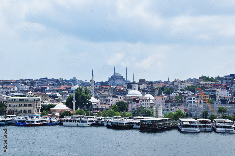 Panoramic views of the Bosphorus, pleasure boats, a mosque and residential buildings.