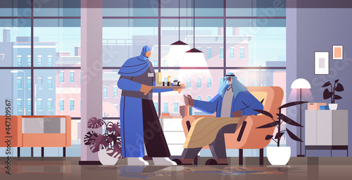 friendly arab nurse or volunteer bringing pills to arabic elderly man patient home care services healthcare