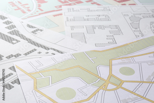 Foto Many different cadastral maps of territory with buildings as background, closeup