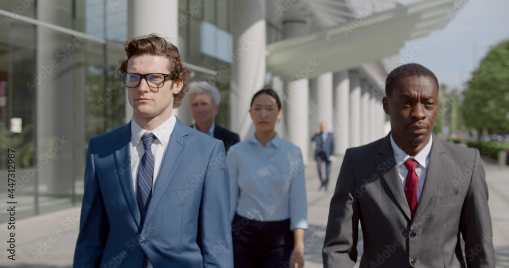 Waist up portrait of diverse business people walk outside office building Waist up portrait of diverse business people walk outside office building