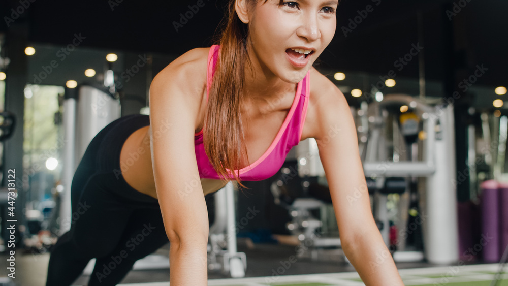 Beautiful young athlete Asian lady exercise doing push-ups fat burning workout in fitness class. Sportswoman recreational activity, functional training, people working out, healthy lifestyle concept.