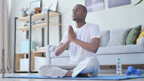African Man Meditating on Yoga Mat at Home