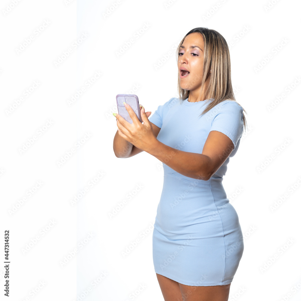 Expresiones de mujer rubia con vestido azul de punto sobre fondo blanco, hablando por el móvil y haciéndose un selfie Expresiones de mujer rubia con vestido azul de punto sobre fondo blanco, hablando por el móvil y haciéndose un selfie