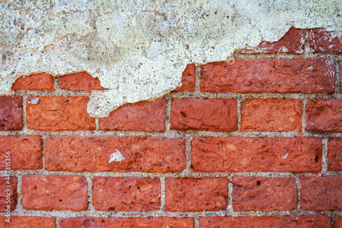 The background of a brick wall with remnants of plaster, the empty texture of an old brick wall.