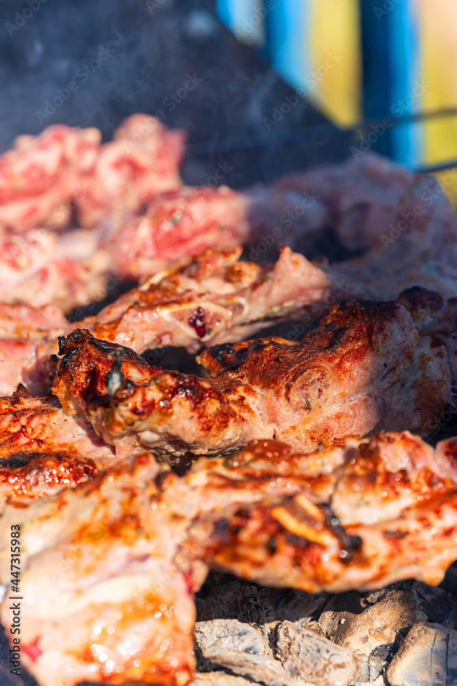 Meat on skewers is fried on coals with smoke