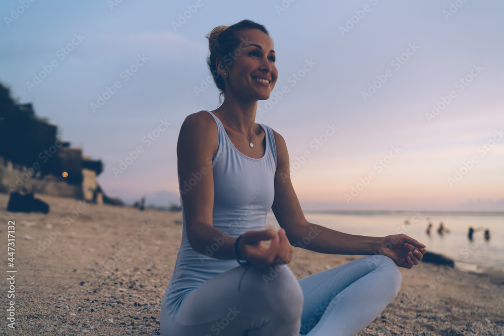 Content ethnic woman practicing yoga on beach
