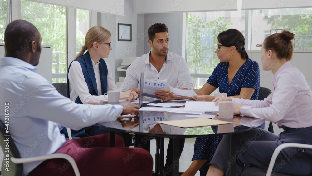 Indian businessman executive in group meeting discussion with employees in modern office Indian businessman executive in group meeting discussion with employees in modern office