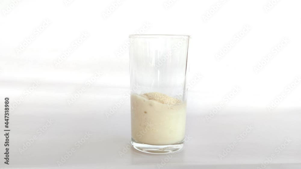 Time laps shot of fermentation of yeast with maida(Wheat floor)inside the drinking glass Time laps shot of fermentation of yeast with maida(Wheat floor)inside the drinking glass