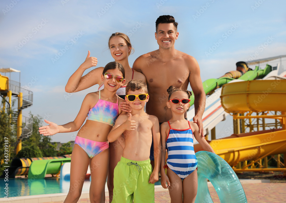 Happy family with inflatable ring near pool in water park - obrazy, fototapety, plakaty 