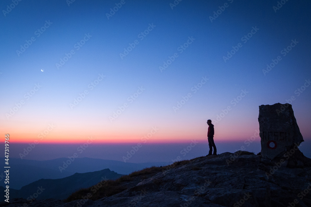 Fototapeta premium Man Observing Dawn at Korab Peak, Northern Macedonia