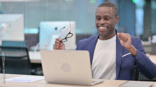 Successful Young African Businessman with Laptop Dancing at Work
