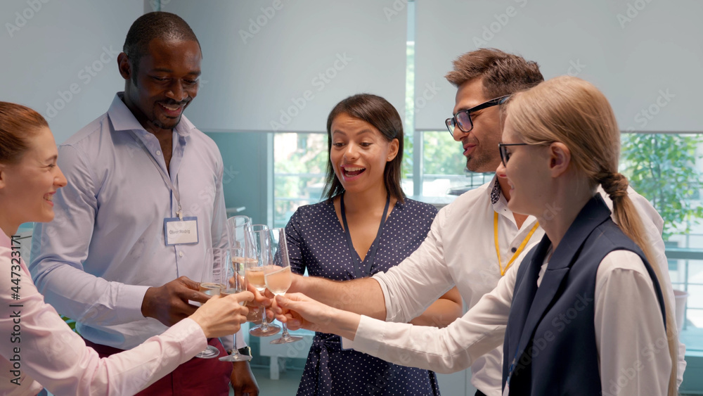 Medium shot of multiethnic colleagues making toast at office party